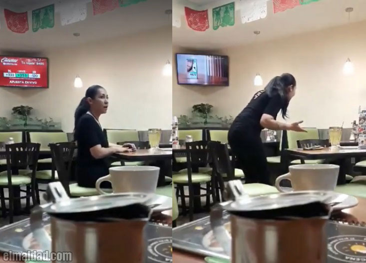 Mujer discute al vacío en un restaurante.