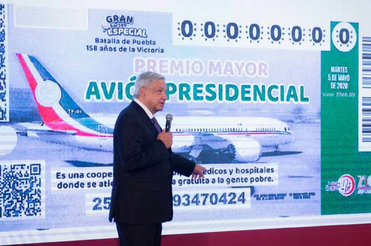 AMLO presentando el boleto de la rifa del avión presidencial.