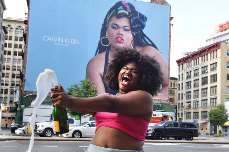 Jari Jones celebrando verse en el enorme afiche de Calvin Klein.