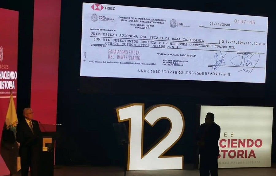 El gobernador Bonilla presentando el cheque del pago de la UABC.