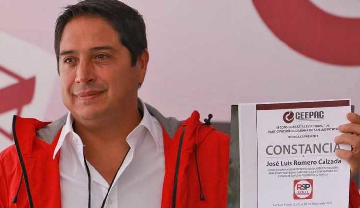 José Luis Romero mostrando su constancia de registro como candidato.