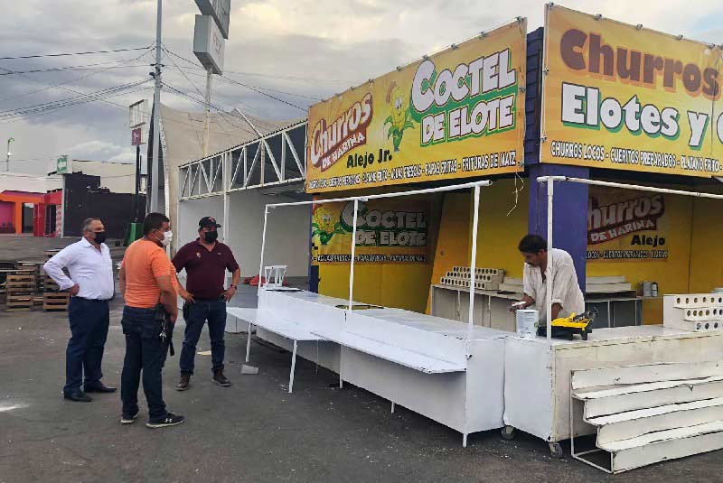 Carlos Río junto a trabajadores del FEX viendo el avance de los puestos de las fiestas del sol.