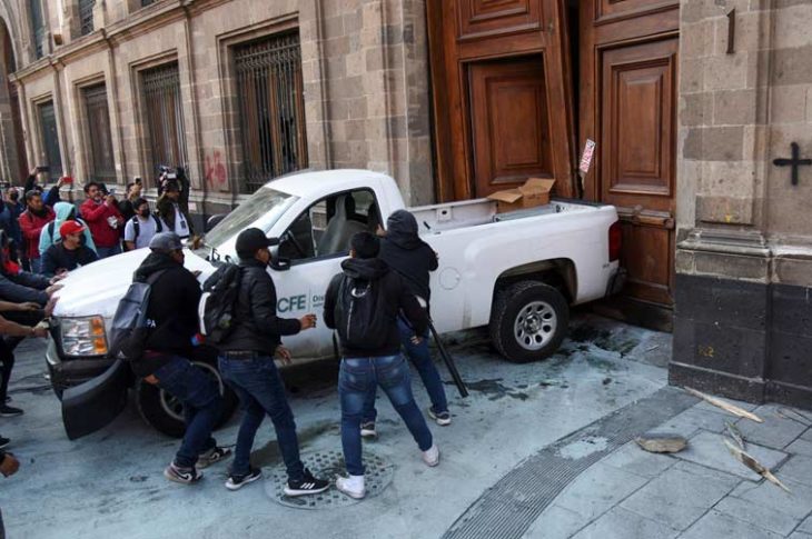 Normalistas derribando puertas de palacio nacional. Foto: El País.