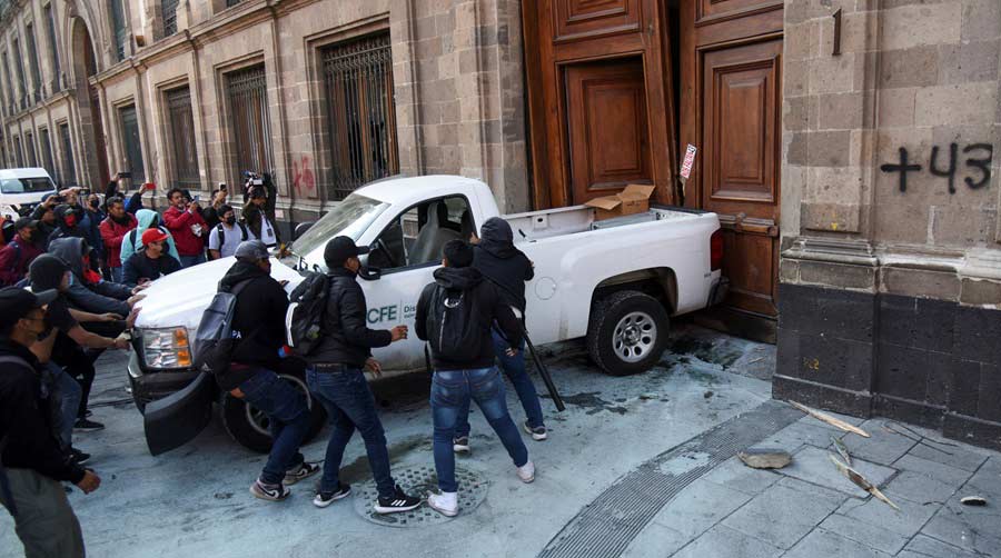 Normalistas derribando puertas de palacio nacional. Foto: El País.
