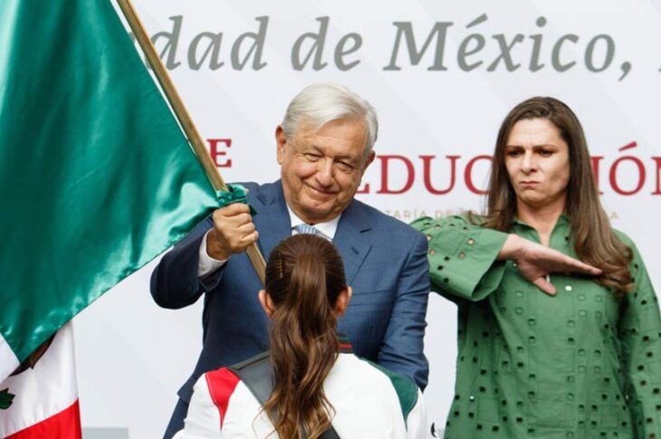 AMLO y Ana Gabriela Guevera entregando la bandera a la delegación mexicana.