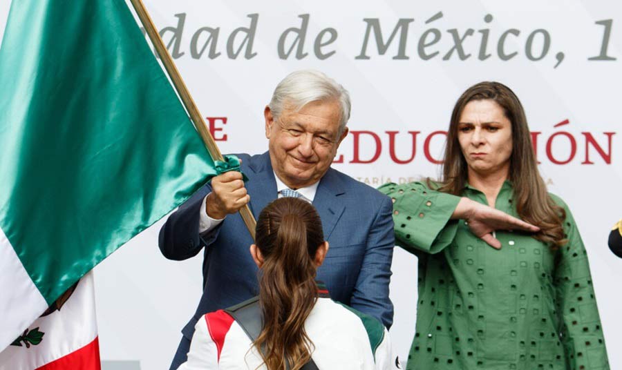 AMLO y Ana Gabriela Guevera entregando la bandera a la delegación mexicana.